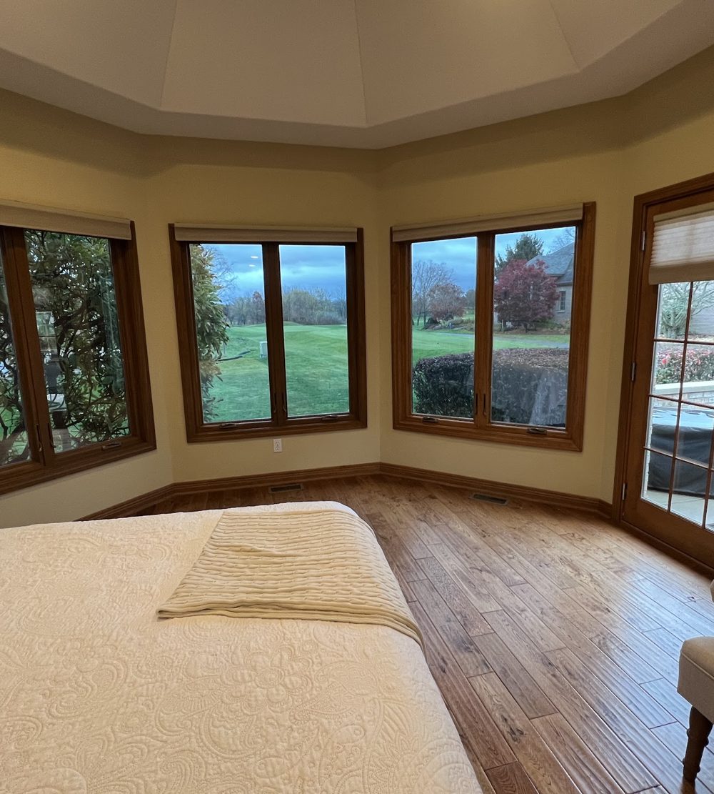 Bedroom bay windows with clear heat and glare control film overlooking a golf course