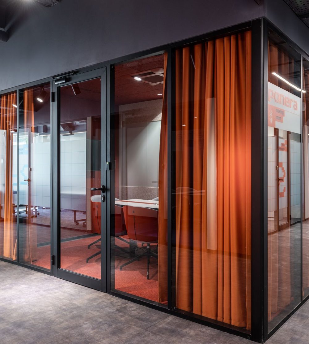 Office corridor lined with glass-walled meeting rooms