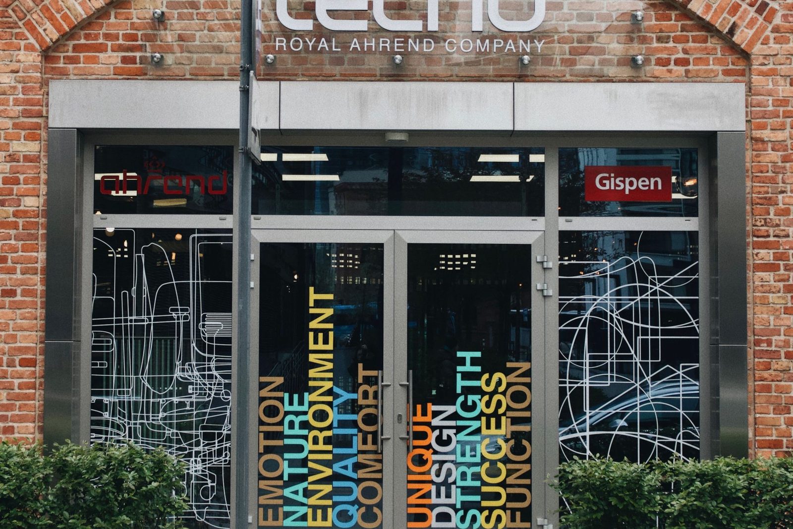 Brick storefront with colourful vinyl window graphics on the glass doors